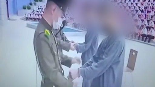 Imagem mostra oficiais norte-coreanos condenando e algemando adolescente norte-coreanos por assistirem dorama na Coreia do Norte. Entenda porque adolescentes norte-coreanos foram condenados a trabalho forçado por assistir doramas
