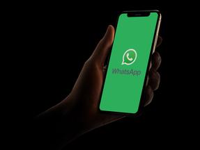 Mão segurando o celular aberto no WhatsApp