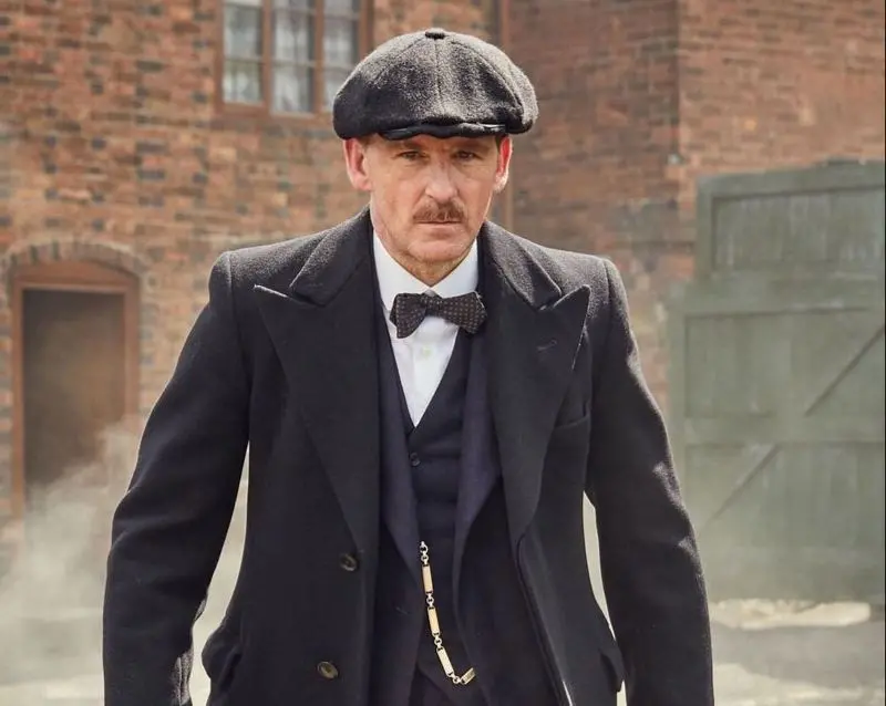 Paul Anderson caracterizado como personagem da série Peaky Blinders. Ele é um homem branco de meia idade e usa bigode