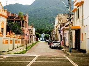 Imagem mostra rua na cidade de Maranguape. No fundo da imagem, vê-se a Serra de Maranguape. As casas na vida pública têm arquitetura antiga e são coloridas.