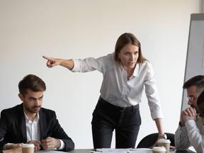 Líder sendo agressiva com colaboradores em reunião de trabalho.