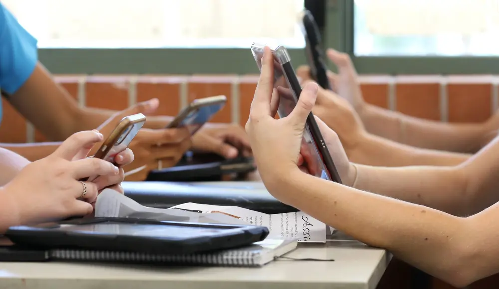 Crianças utilizam celular em sala de aula