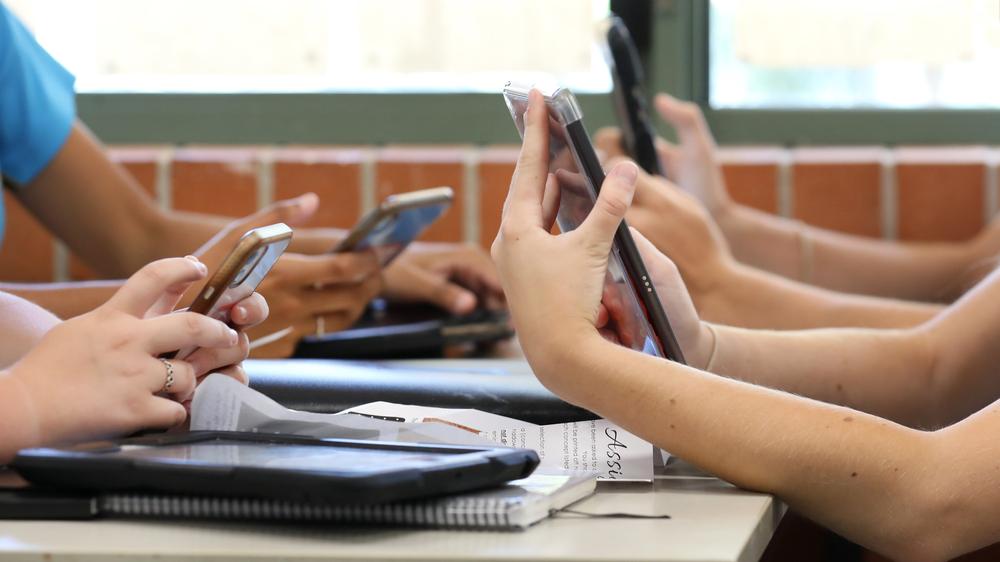 Crianças utilizam celular em sala de aula
