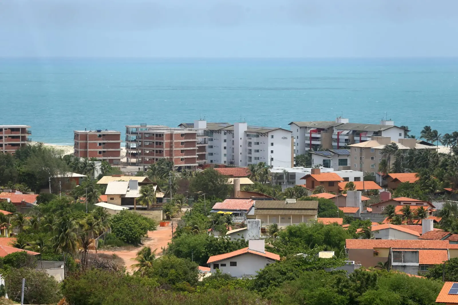 Foto que contém imóveis no Porto das Dunas, ao fundo o Oceano Atlântico