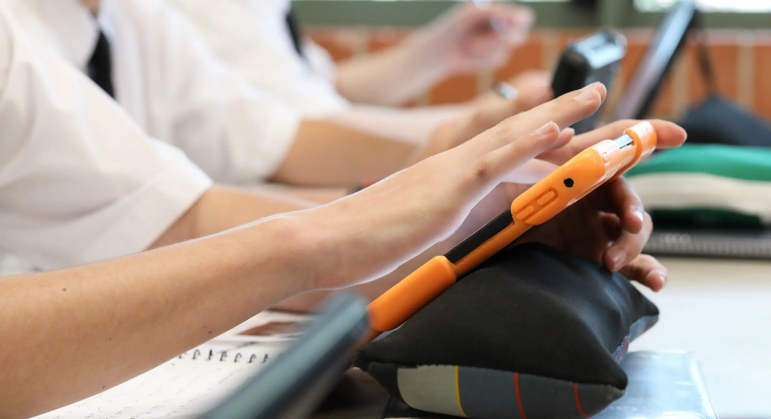 Jovens utilizam equipamento eletrônico na escola