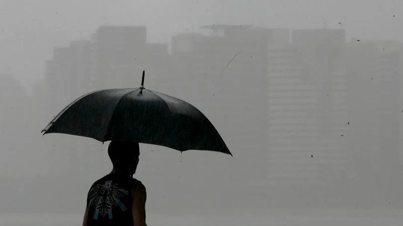 Homem de guarda-chuva diante de neblina