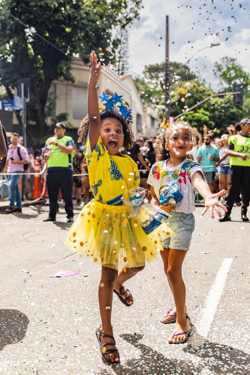 Menina negra e menina branca com confetes de carnaval na rua