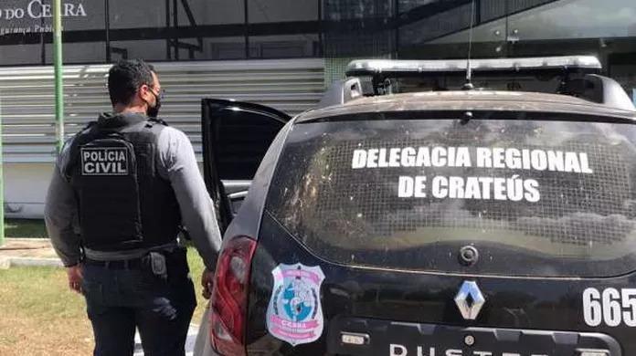 Policial civil ao lado de viatura da Delegacia Regional de Crateús