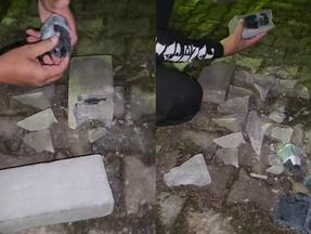 Policial penal quebrando tijolos que tinham drogas e celulares dentro de presídio