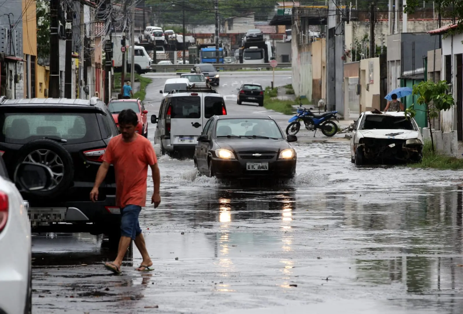 Carros trafegando por rua alagada