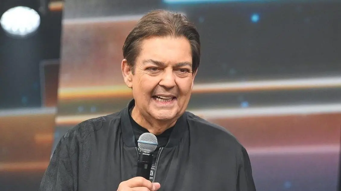 Faustão segura microfone enquanto fala durante apresentação
