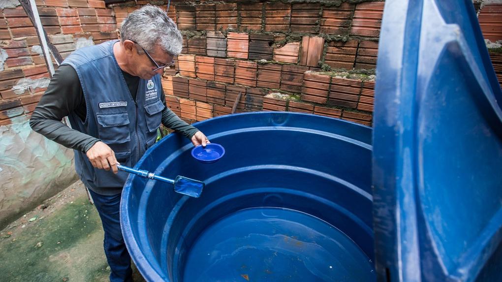 Agente de endemias verifica possíveis larvas do mosquito Aedes aegypti em caixa d'água em Fortaleza