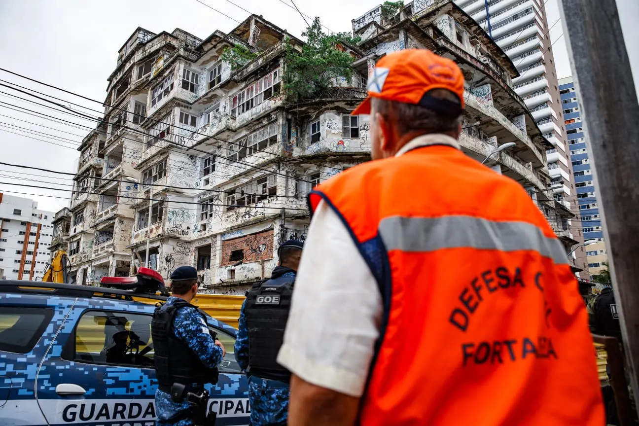Profissional da Defesa Civil de Fortaleza de costas para a foto e de frente para o edifício São Pedro