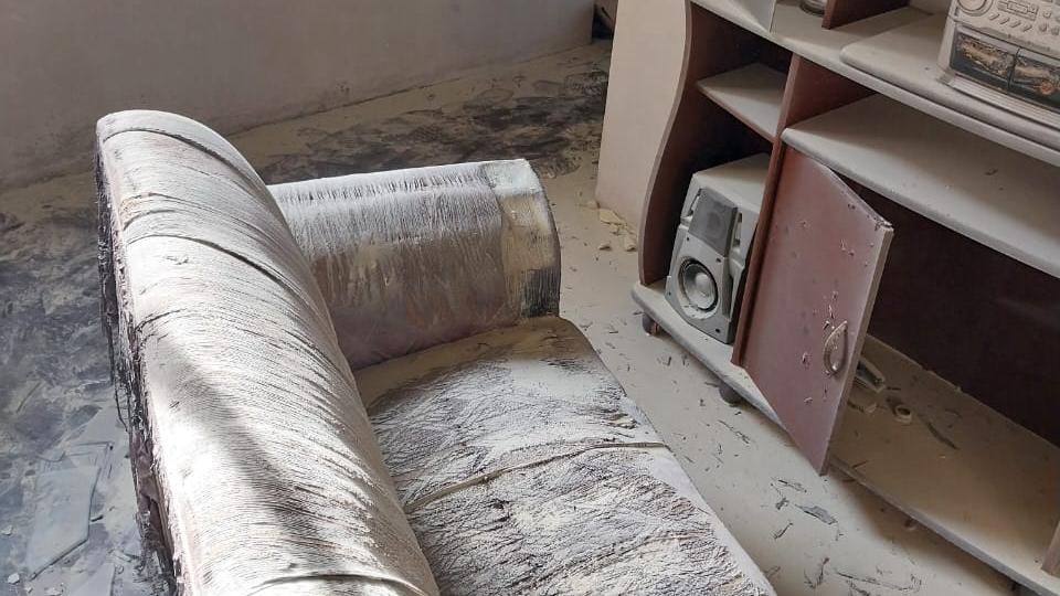Imagem mostra móveis de sala cobertos por cinzas em apartamento que pegou fogo após explosão, em 13 de março de 2023, no distrito de Jurema, em Caucaia. Idosa fica gravemente ferida em explosão seguida por incêndio no próprio apartamento em Caucaia