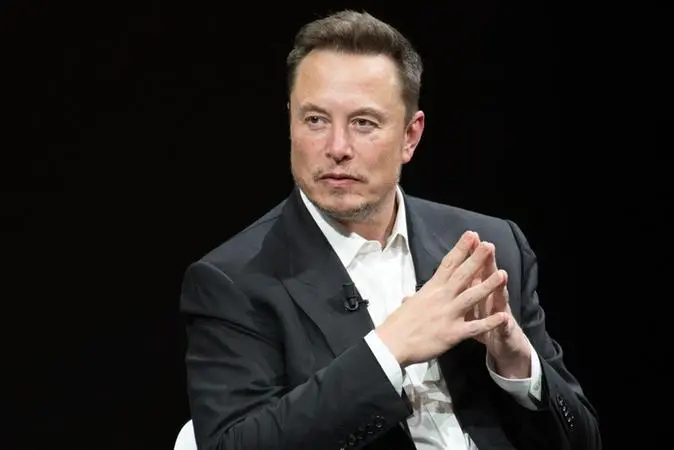 Elon Musk de terno preto durante palestra em evento