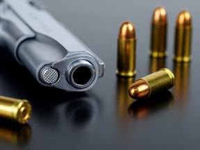 Revólver e munições dispostos em cima de uma mesa