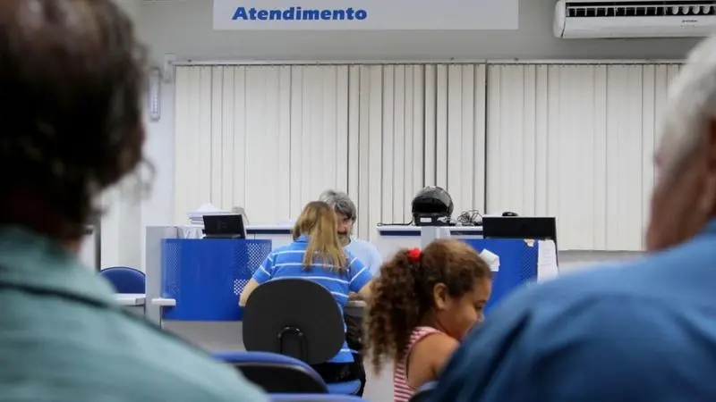 Pessoas em sala de espera da previdência
