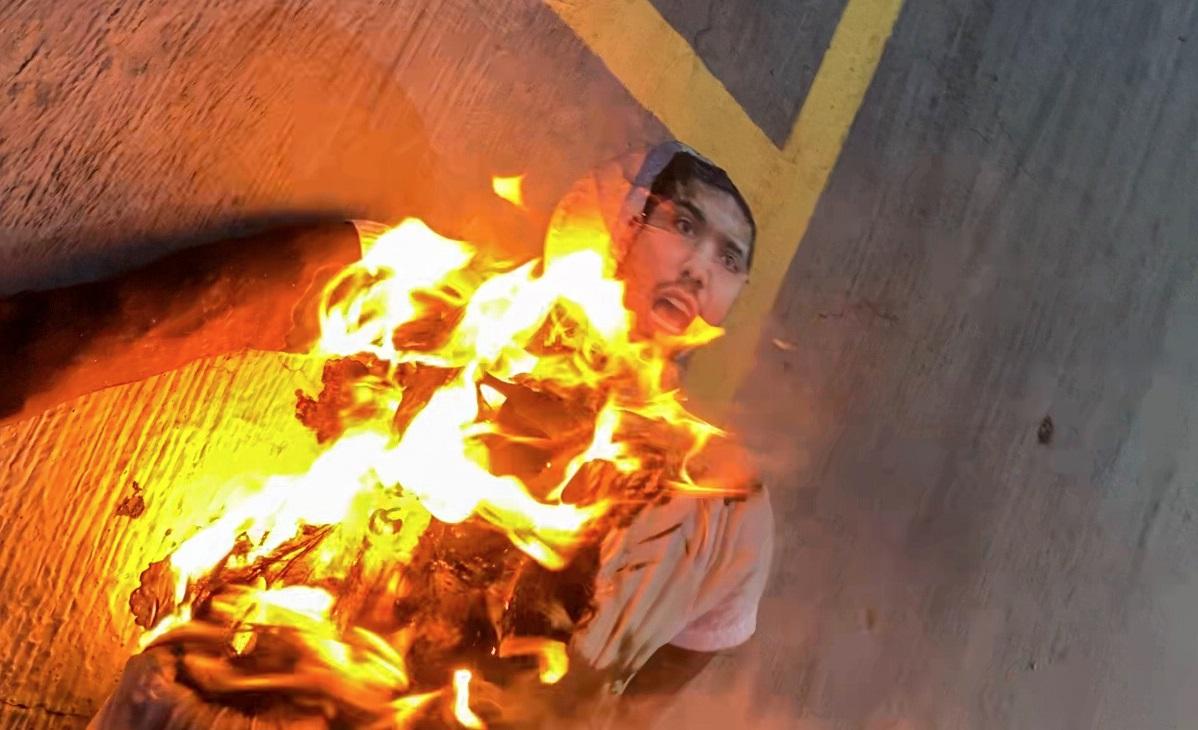 Boneco com rosto de André Fernandes em chamas