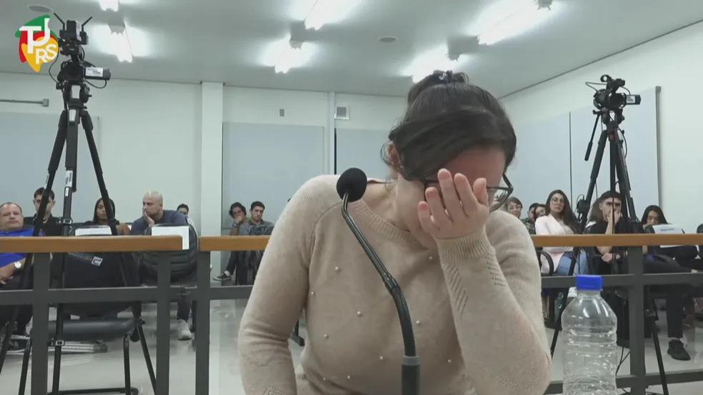 Mulher com mão no rosto durante julgamento