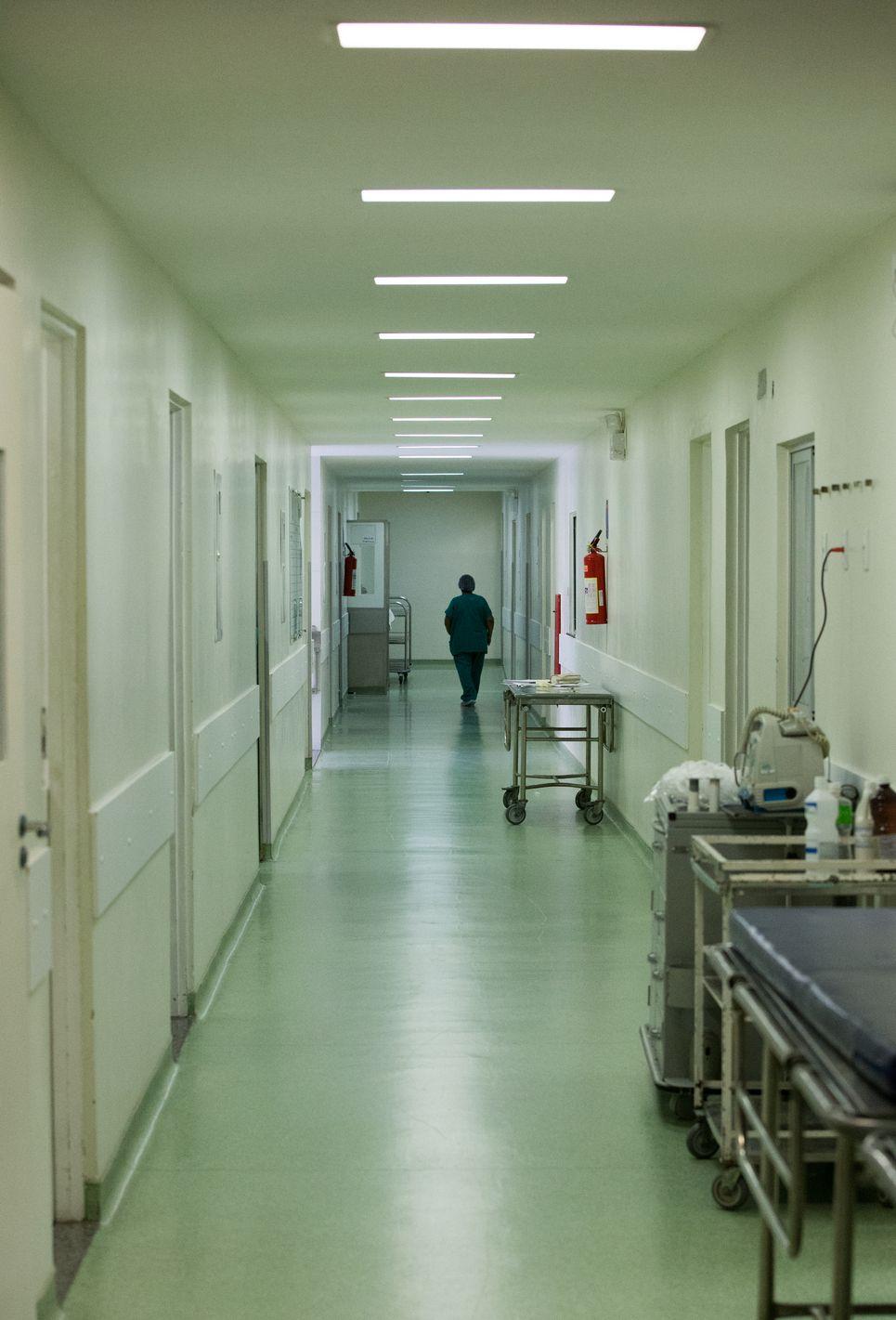 Enfermeira anda em corredor de hospital