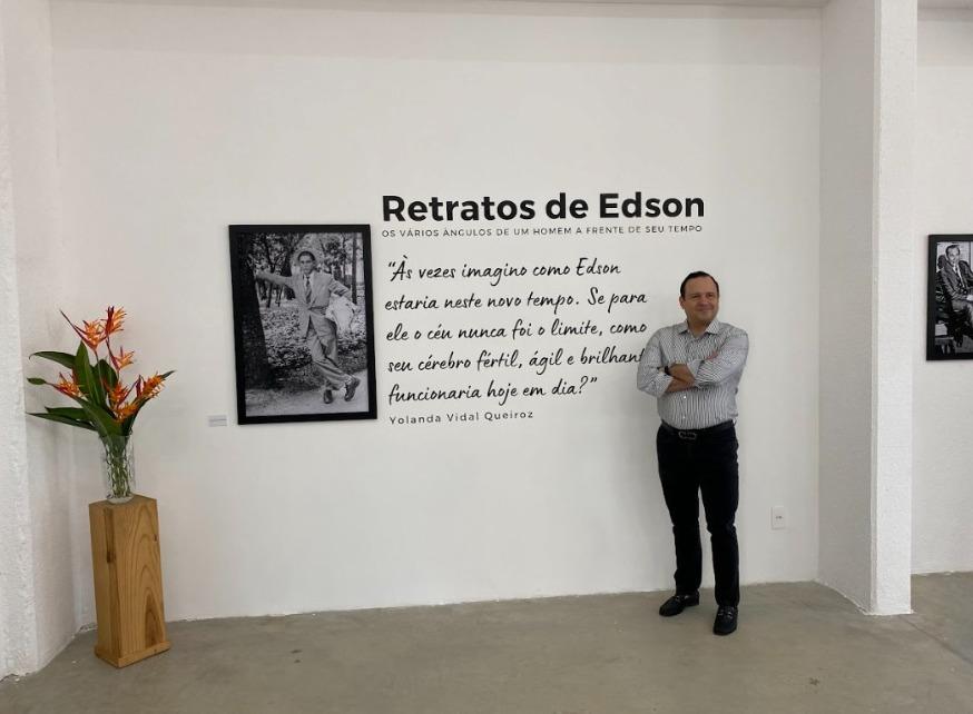 Igor Queiroz Barroso posa para foto ao lado da abertura da exposição sobre Edson Queiroz