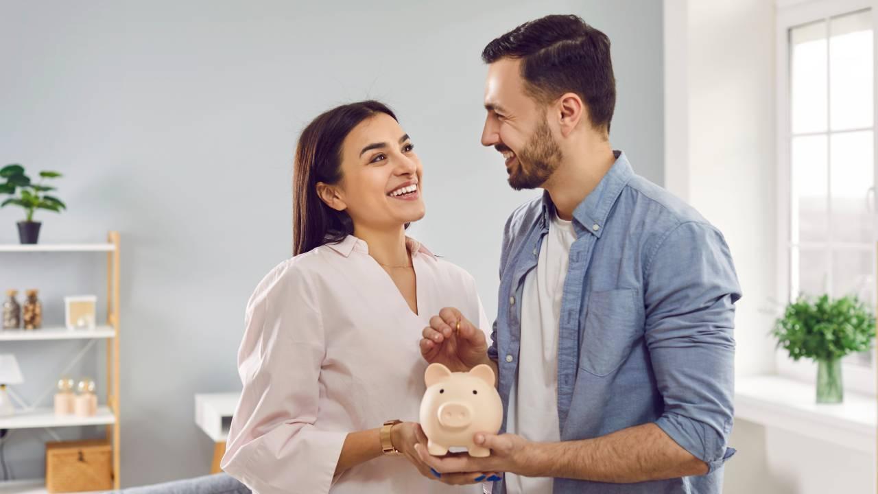 Casal segurando um cofre porquinho