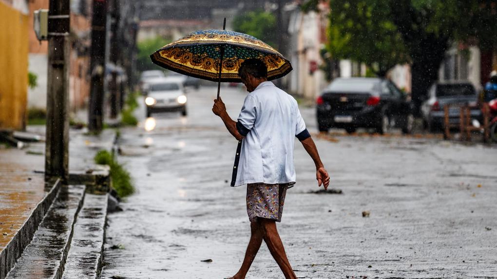 Homem andando na rua molhada durante a chuva em Fortaleza