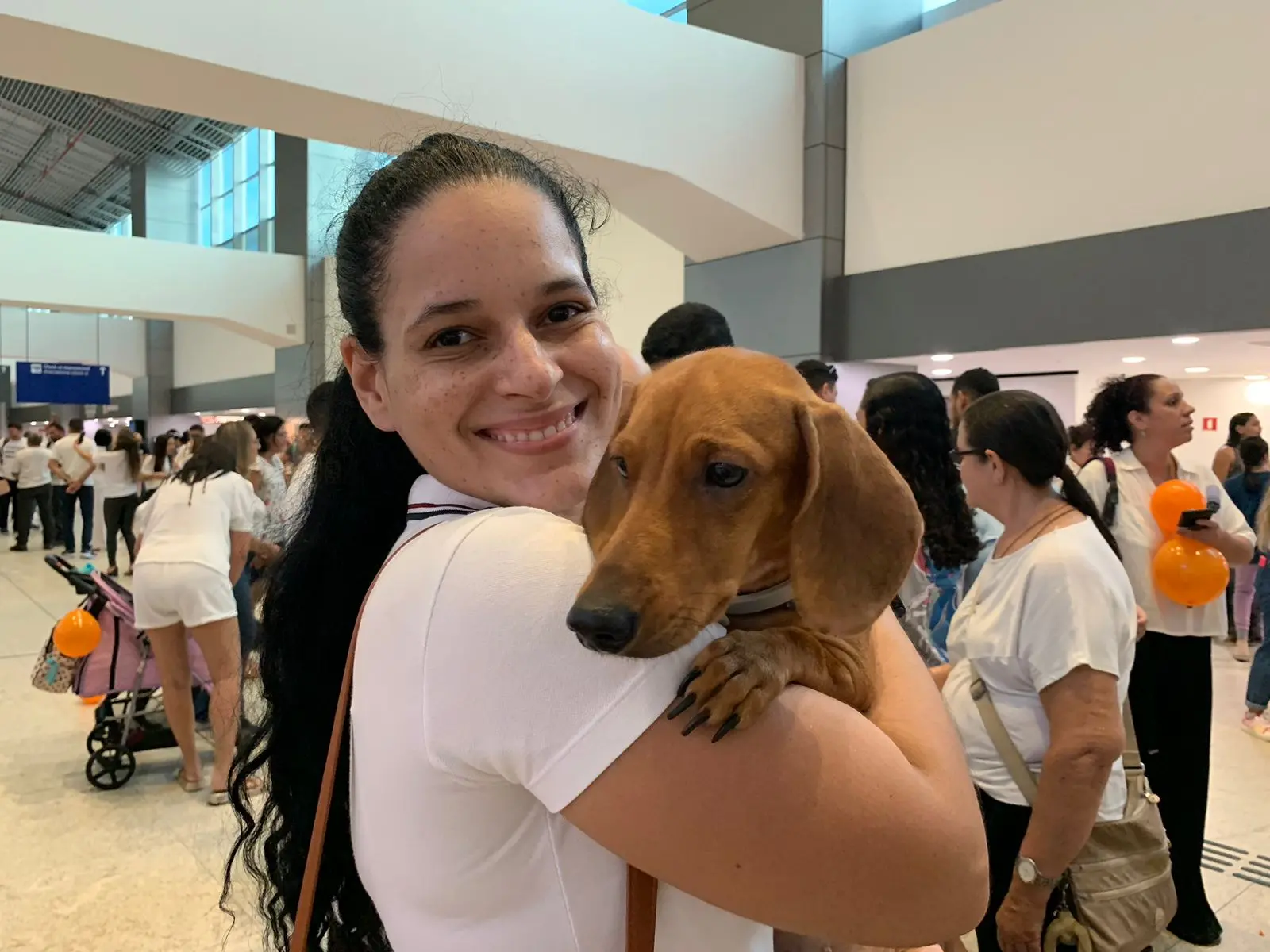 Tutora segura cachorra no aeroporto