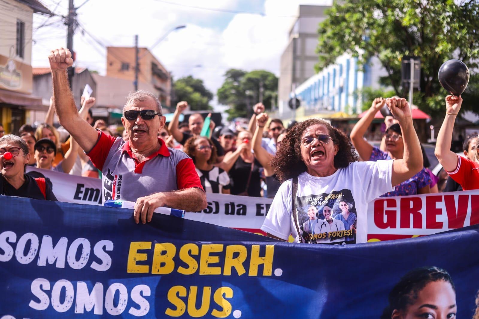 Trabalhadores em greve seguram cartazes