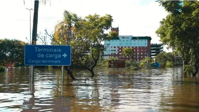 Área externa do Aeroporto Salgado Filho, em Porto Alegre. Água cobre asfalto de acesso à área de cargas do aeroporto