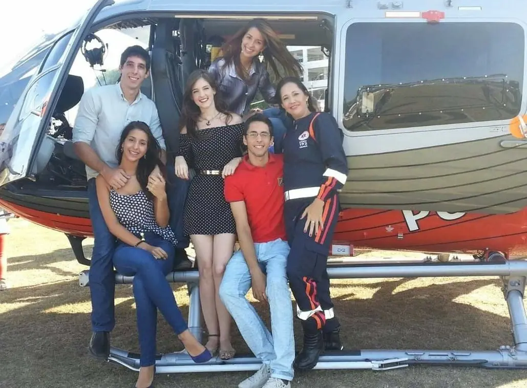 Neiva e os filhos na frente de helicóptero da Ciopaer