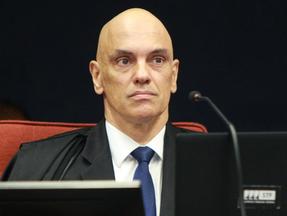 Alexandre de Moraes é um homem branco e careca. Na foto, ele está sério e usa terno preto com camisa branca e gravata azul
