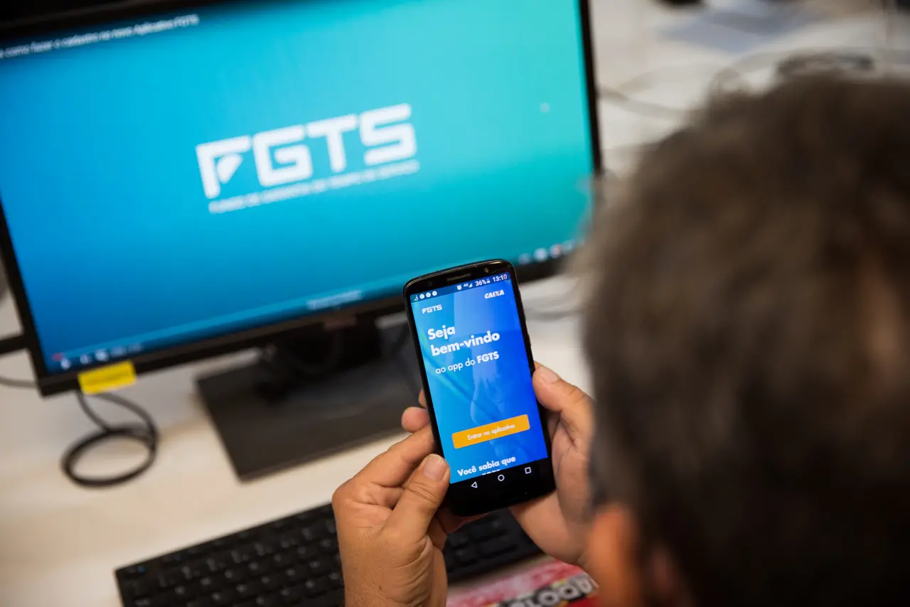 Foto de trabalhador acessando aplicativo do FGTS