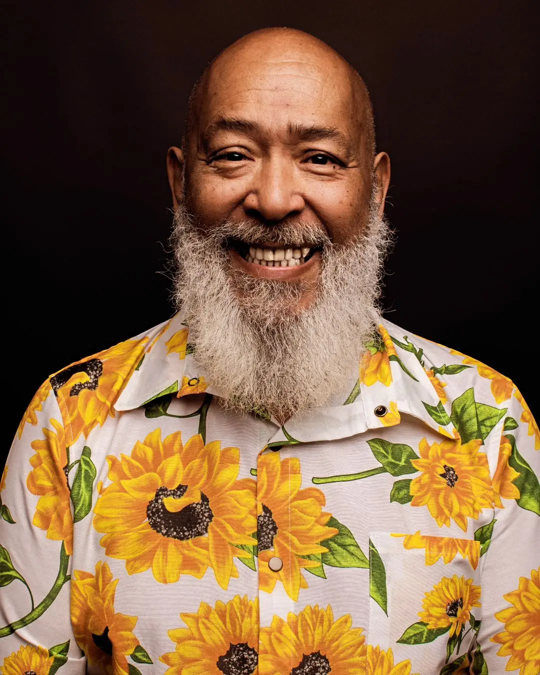 músico skowa diante de um fundo preto com camisa floral