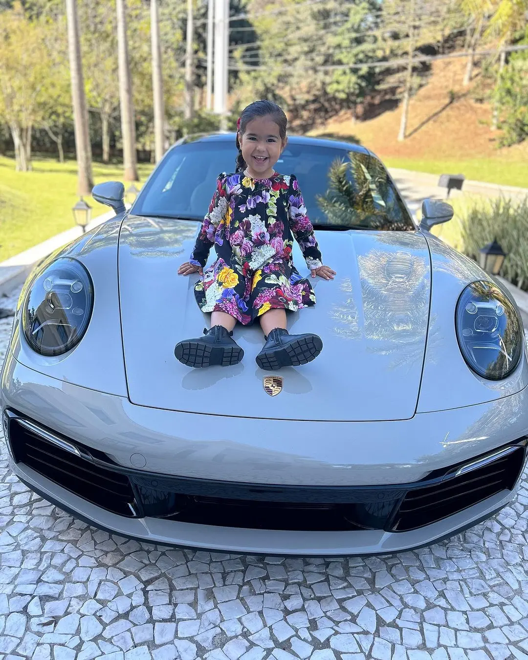 criança sentada em cima de porsche