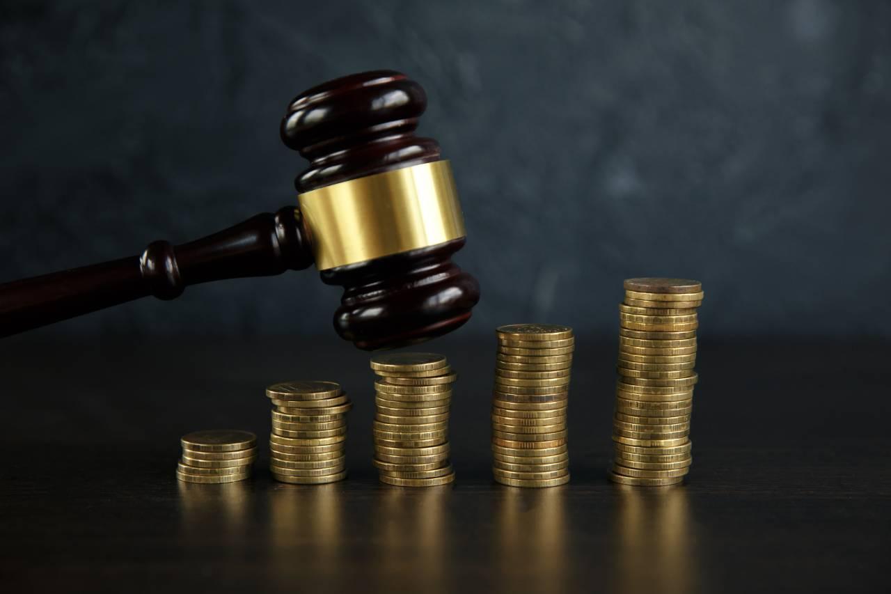 Matelo do Direito e pilhas de moedas sobre uma mesa