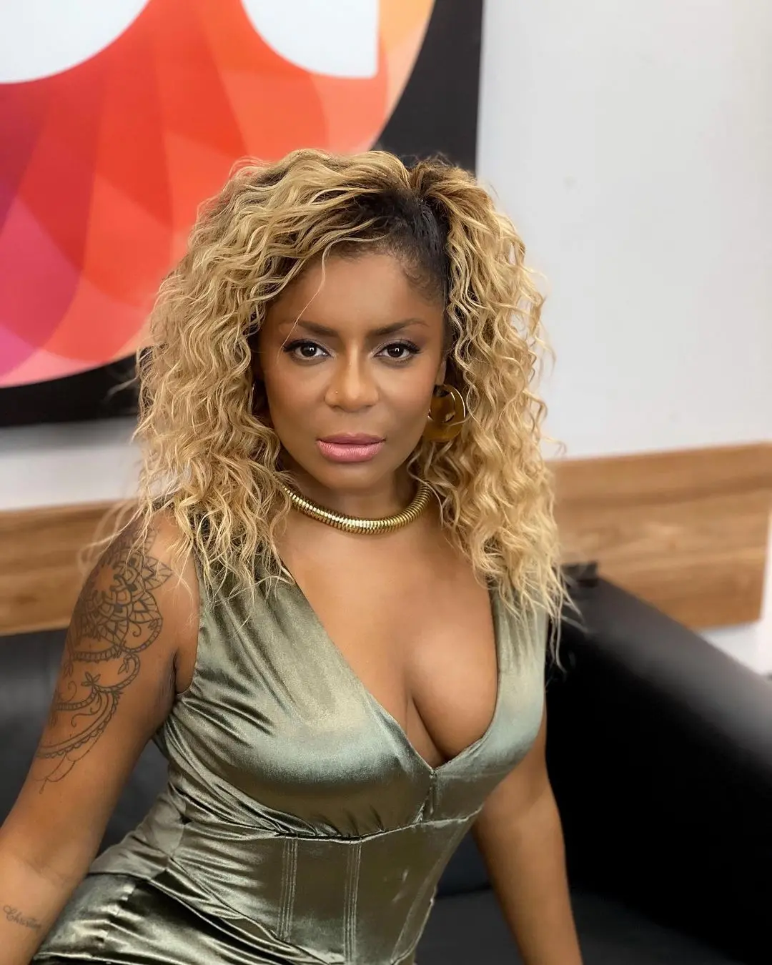 Mulher negra de cabelo cacheado loiro e olhos castanhos