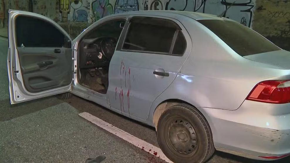 Sangue das vítimas no carro alvejado por disparo