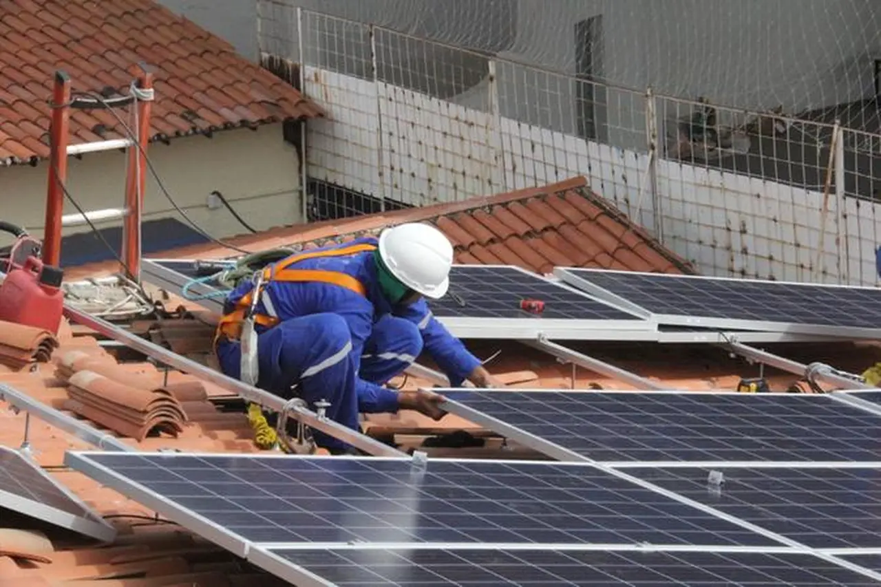 Operário instalando placa de energia solar