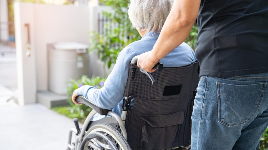 Cuidador empurra cadeira de rodas com idosa. Canadá concederá residência permanente a estrangeiros que atuem como cuidadores; entenda