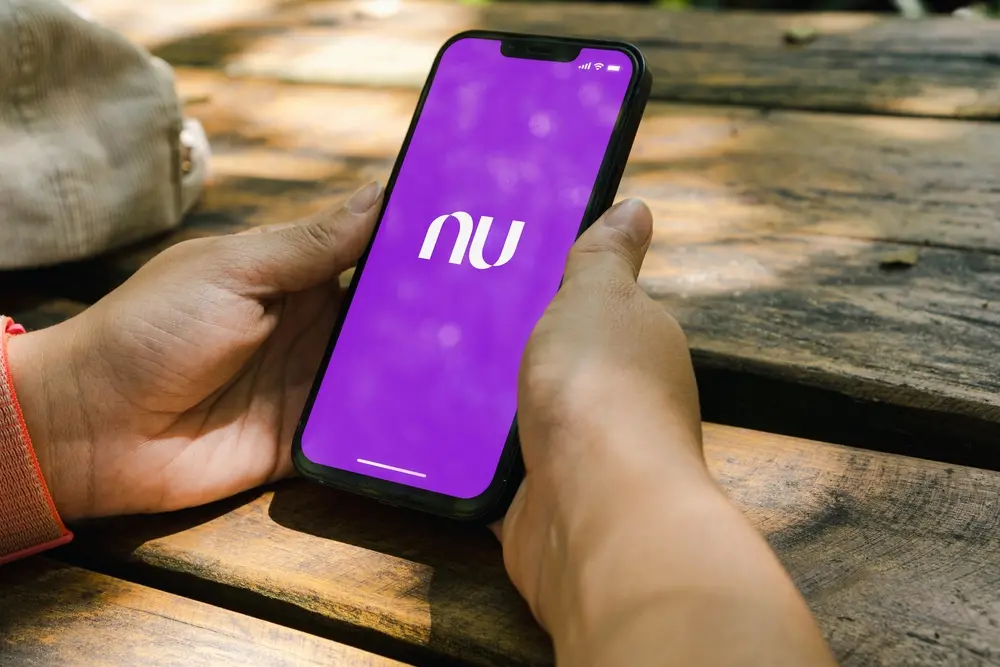Mão segura o celular no aplicativo do Nubank