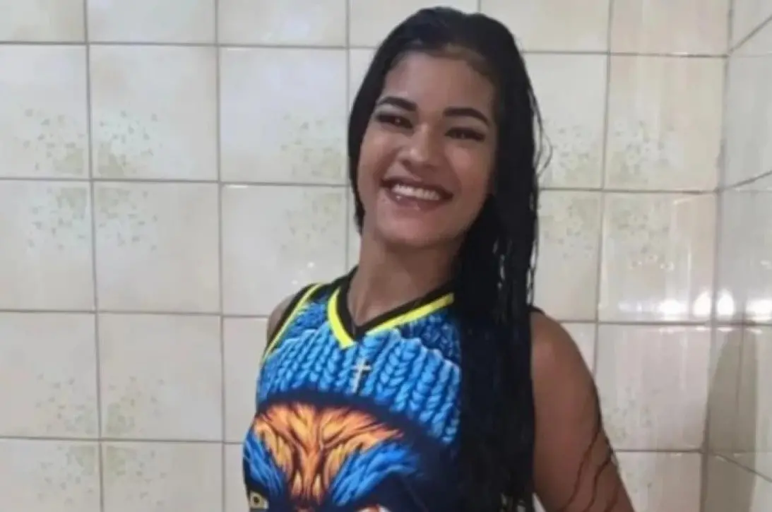 Camille Vitória é uma jovem negra de pele clara e longos cabelos pretos e lisos. Na foto, ela está sorrindo e usa uma blusa com estampa de animal print