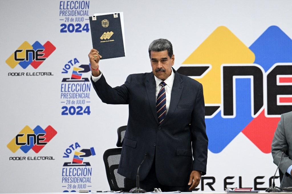 Nicolás Maduro exibe o documento após ser proclamado vencedor da eleição presidencial de domingo, na sede do Conselho Nacional Eleitoral (CNE) em Caracas
