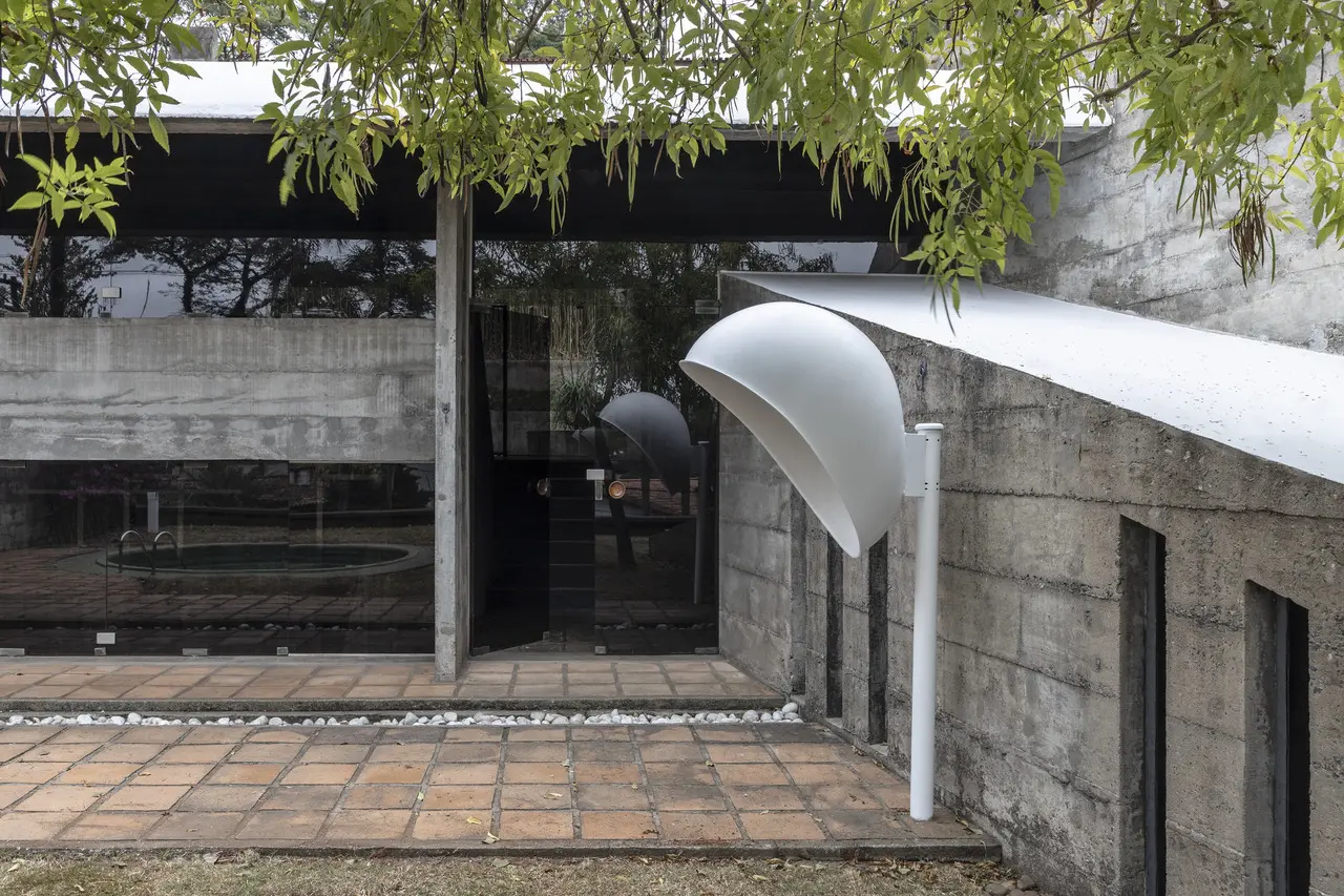 Protótipo do orelhão se destaca em meio ao jardim da casa e relembra a maior obra da designer