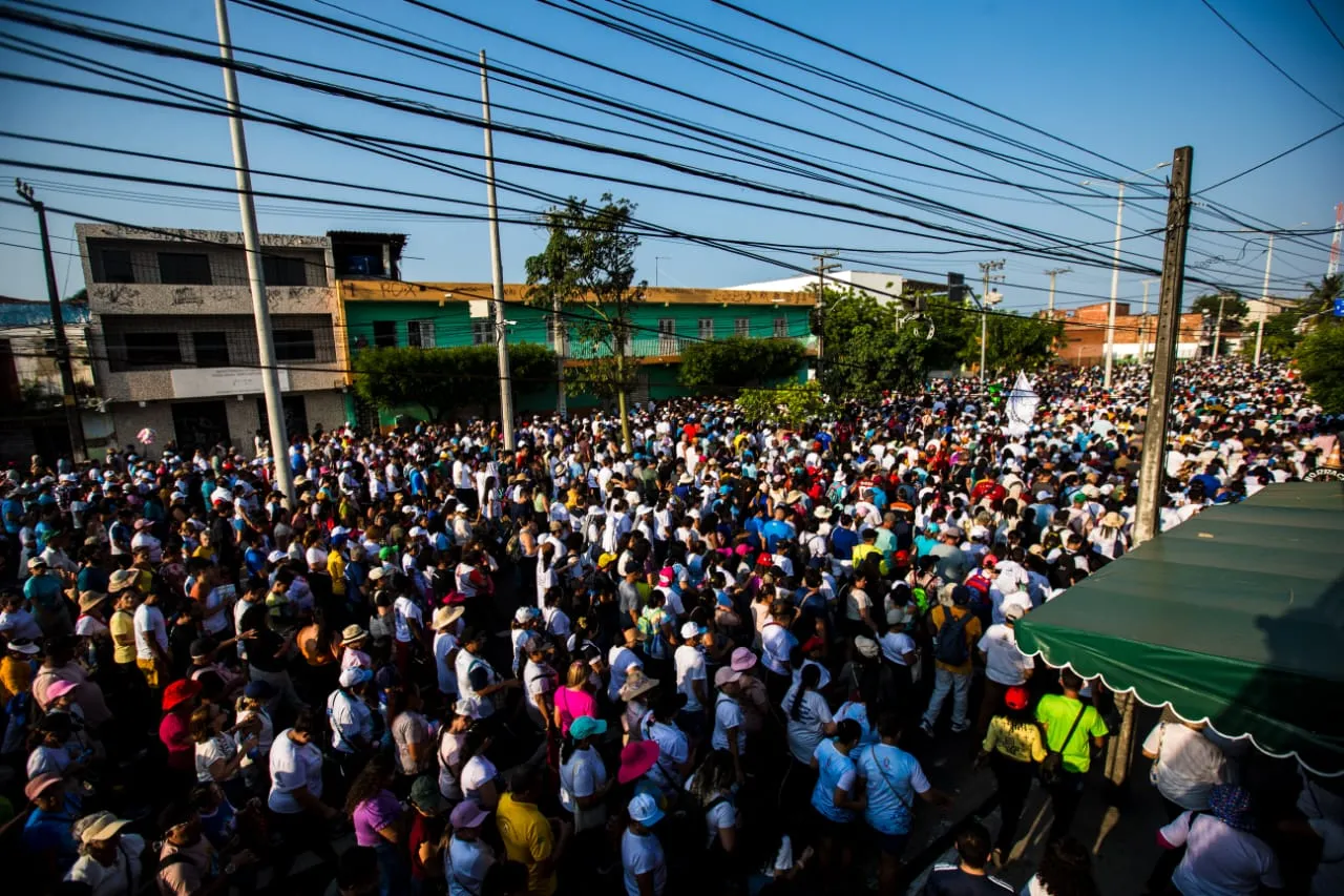 Fiéis caminham realizando orações e cantos