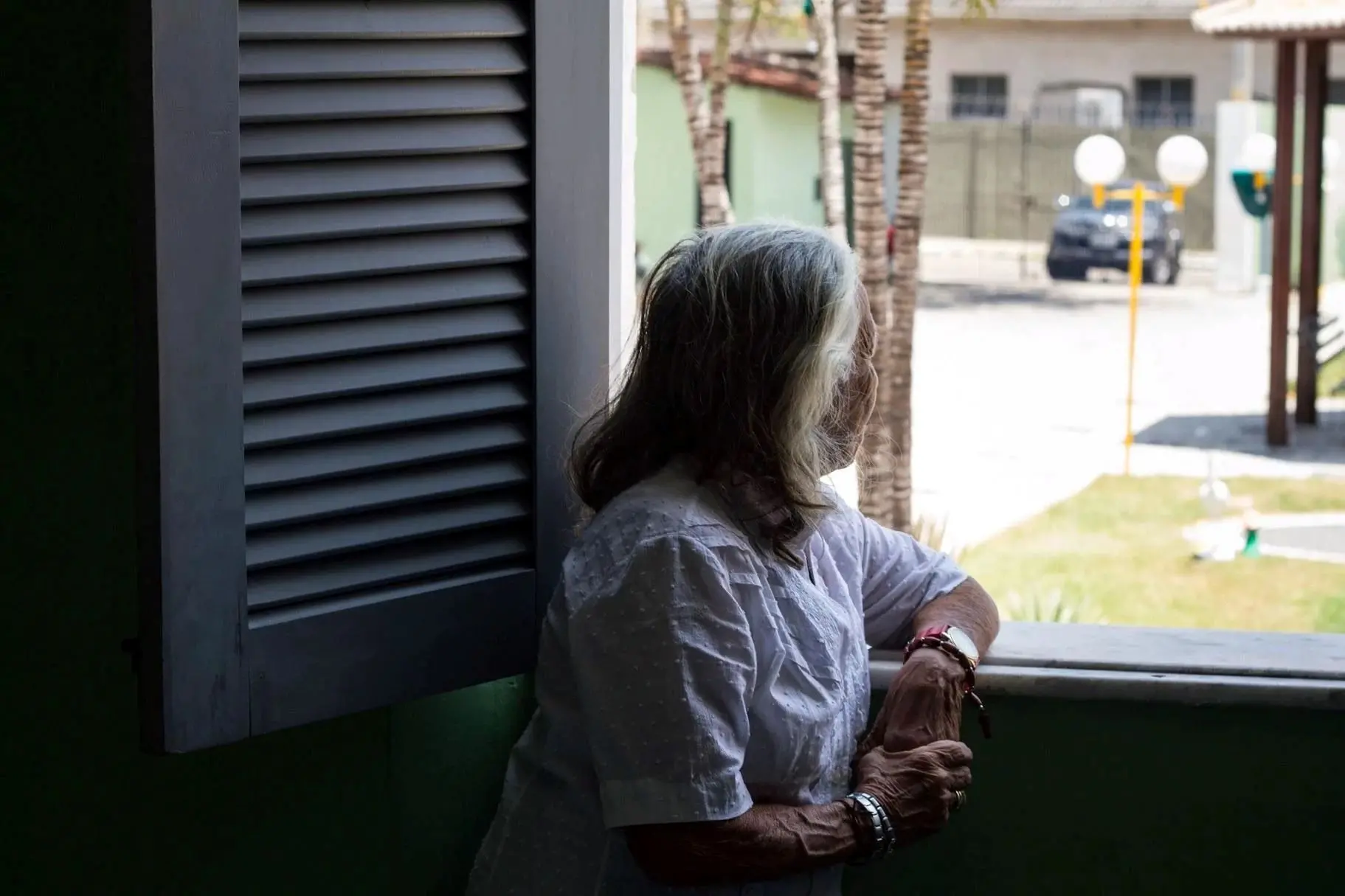 Pessoa idosa olhando pela janela