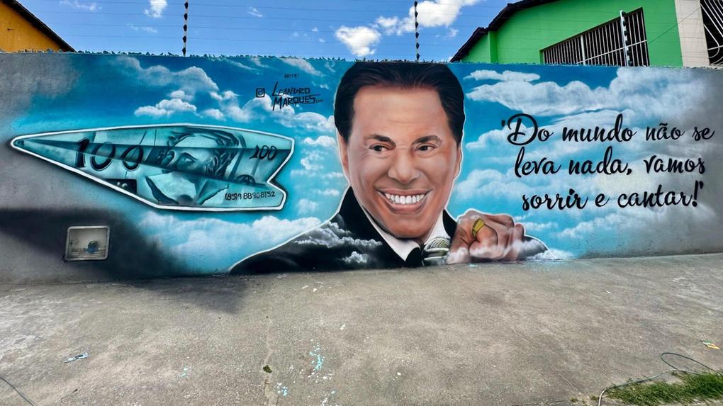Imagem leva Silvio Santos sorridente com detalhes do microfone e até anel de ouro, além do 'aviãozinho'