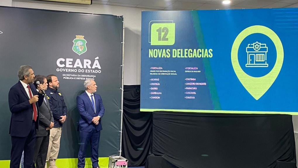 governador elmano de freitas diante de telão com informações sobre novas delegacias