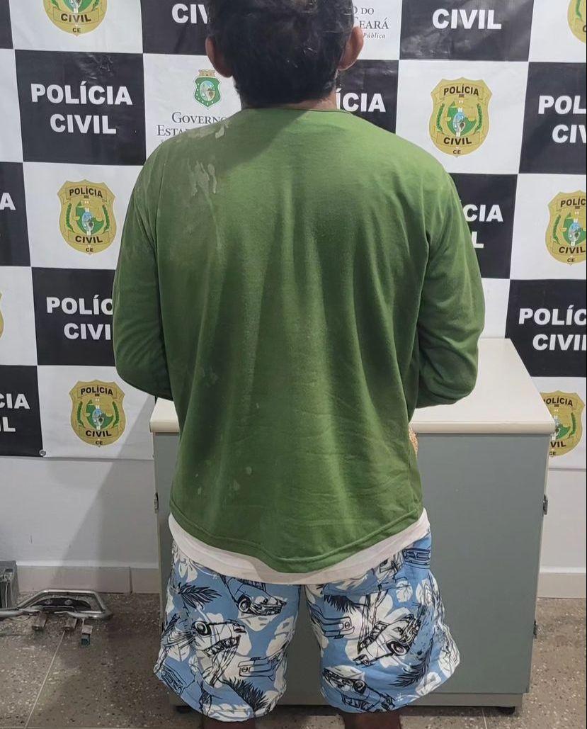 Homem preso por estuprar sobrinha preso na delegacia. Na foto, ele está de costas e com uma blusa verde e short