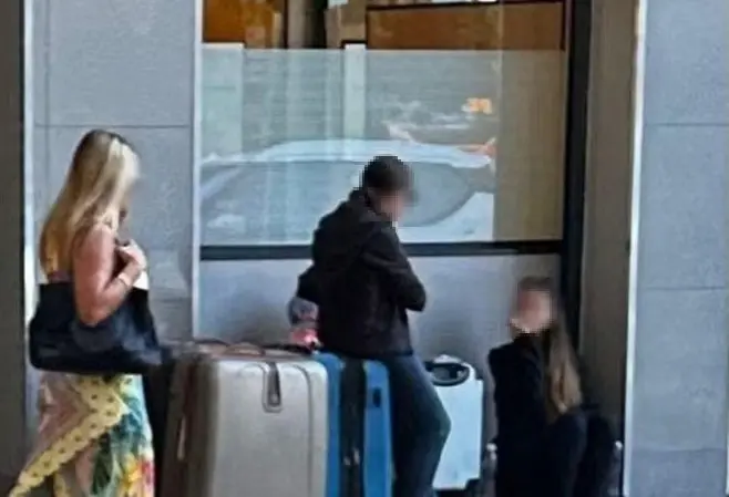 Imagem mostra mãe e filha com malas em um McDonald's no Rio de Janeiro. Elas estão com os rostos borrados